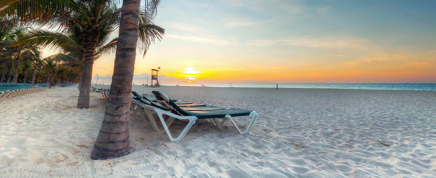 Beach chairs on a Caribbean beach at sunset