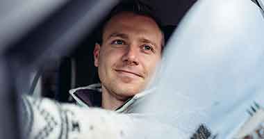 man looking out of driver's side car window