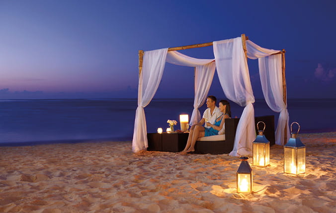 Honeymoon couple relaxing on the beach at night