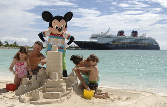 Parents and kids building a sandcastle with Mickey Mouse