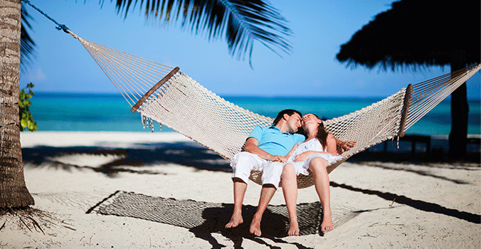 Couple enjoying hammock on tropical beach