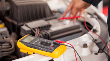 Closeup of a mechanic hands checking a car battery at an auto shop